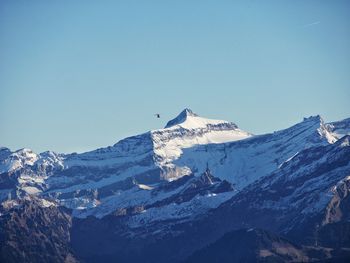 Scenic view of snowcapped mountains against clear blue sky