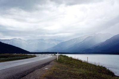 Road by mountains against sky