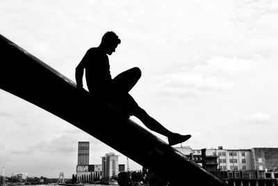 Low angle view of silhouette person against sky in city