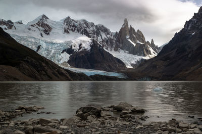 Scenic view of mountains and lake against cloudy sky