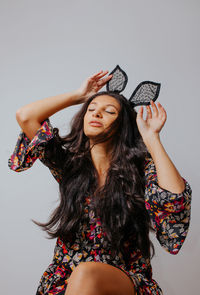 Young woman wearing mask against white background