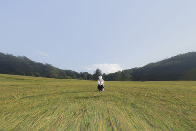 People walking on field against mountain