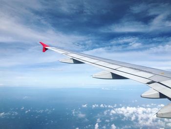 Cropped image of aircraft wing flying in sky