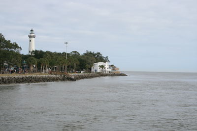 View of lighthouse by sea against sky