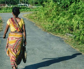 Rear view of woman wearing sari walking on road