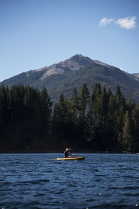 Man on boat in river against sky