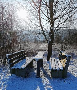 Empty bench in park during winter