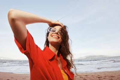 Portrait of young woman standing at beach