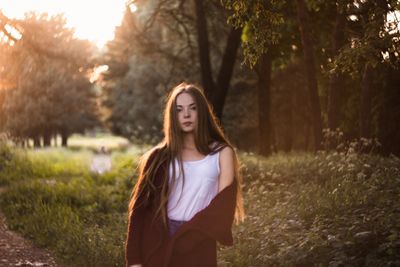 Portrait of young woman standing in park