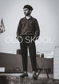 Full length portrait of young man standing against wall