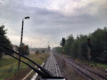 Road seen through wet car windshield