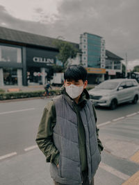 Young man standing on street in city