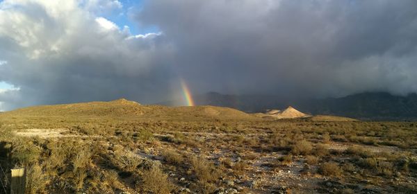 Scenic view of rainbow over land against sky