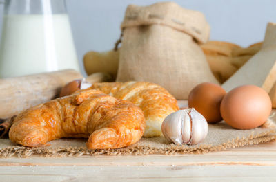 Close-up of croissant and ingredients on table