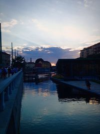 Canal in city at sunset