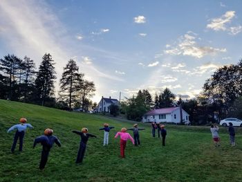 People playing on field against sky