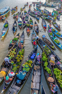High angle view of market vendors selling food on rowboats in lake