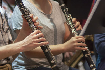Midsection of artists playing flute during event