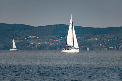 Sailboat sailing on sea against sky