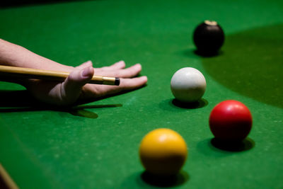 Cropped hand playing pool at table