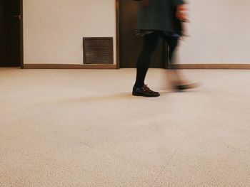 Low section of woman walking on tiled floor