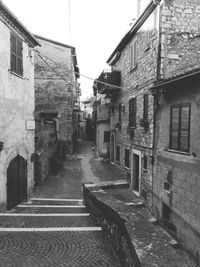 Footpath amidst buildings against sky