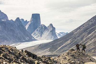 Backpackers high five after a successful mountain climb.