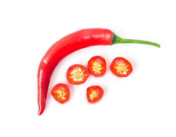 Close-up of red chili peppers over white background