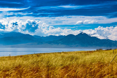 Scenic view of lake and mountains against cloudy sky