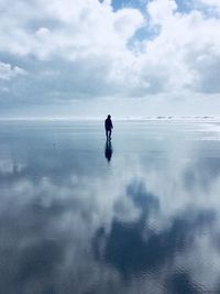 Man standing on beach against sky