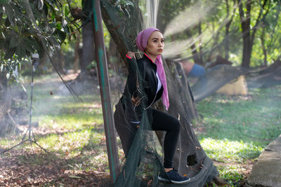 Portrait of young woman standing in forest