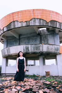 Woman standing against abandoned building