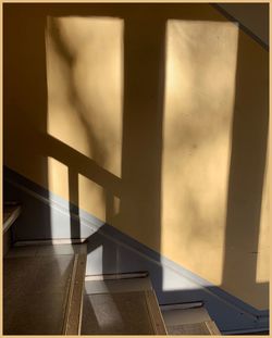 Shadow of railing on staircase by window in house
