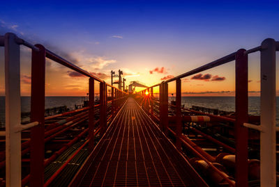 Bridge over sea against sky during sunset