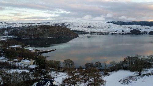 Scenic view of lake and snowcapped mountains against sky