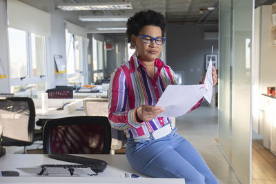 Full length of a young man sitting on paper