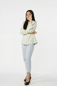 Portrait of a smiling young woman against white background