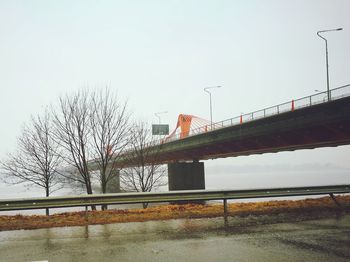 Bridge over trees against clear sky