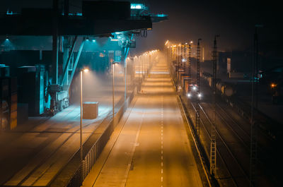 Illuminated railroad station platform at night