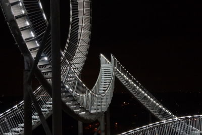 Low angle view of illuminated bridge against sky at night