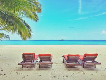 Chairs on beach against sky