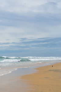 Surfers on the sea, turquoise water, blue sky. arugam bay, sri lanka. portrait format