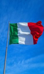 Low angle view of flag against blue sky