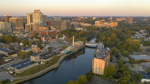 High angle view of buildings by river against sky