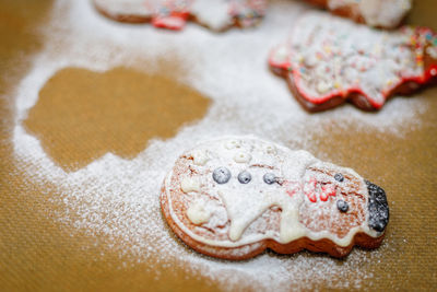 Christmas cookies sprinkled with icing sugar on a baking sheet.