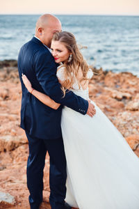 Full length of couple standing on beach