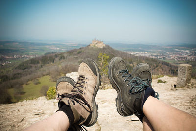 Low section of people on mountain against sky