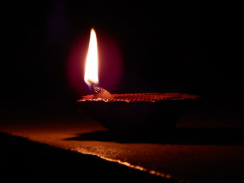 Close-up of lit candle in the dark