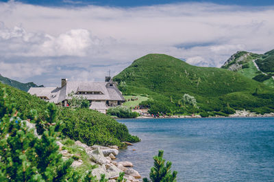 Buildings by sea against sky