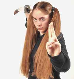 Portrait of young woman holding hands over white background